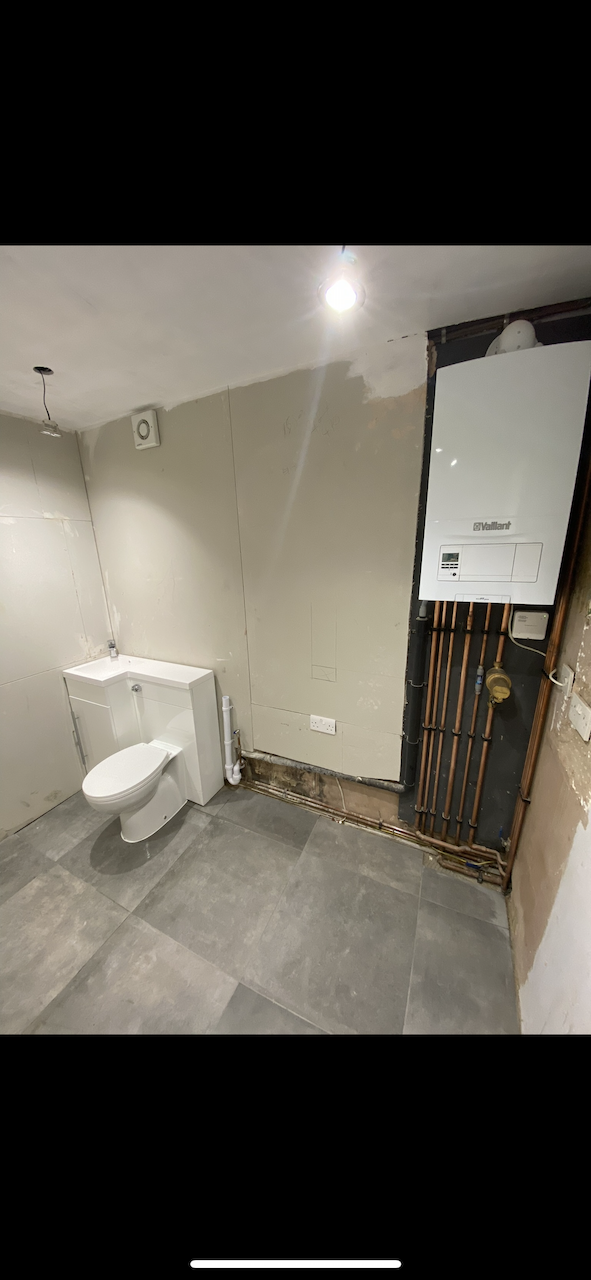 Finished room with Vaillant boiler, toilet and basin unit, tiled floor