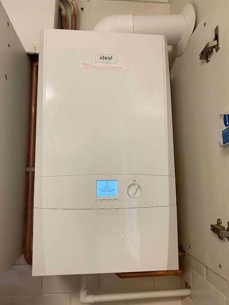 New Ideal combi boiler wall-mounted with copper pipework below
