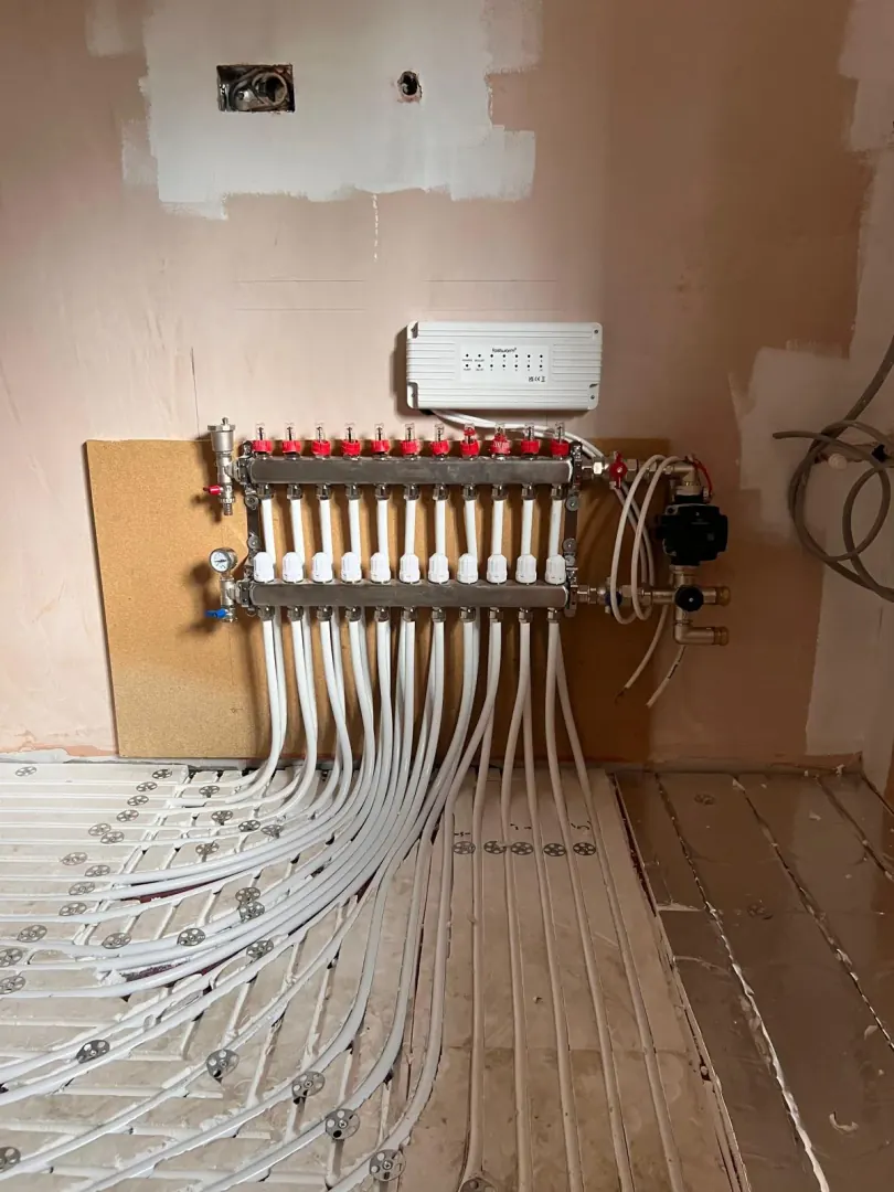 Multi-zone underfloor heating manifold with actuators and wiring centre on the wall